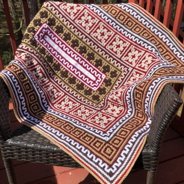 Cozy Cuddles Mosaic Crochet Blanket on Chair in Bright Sunshine